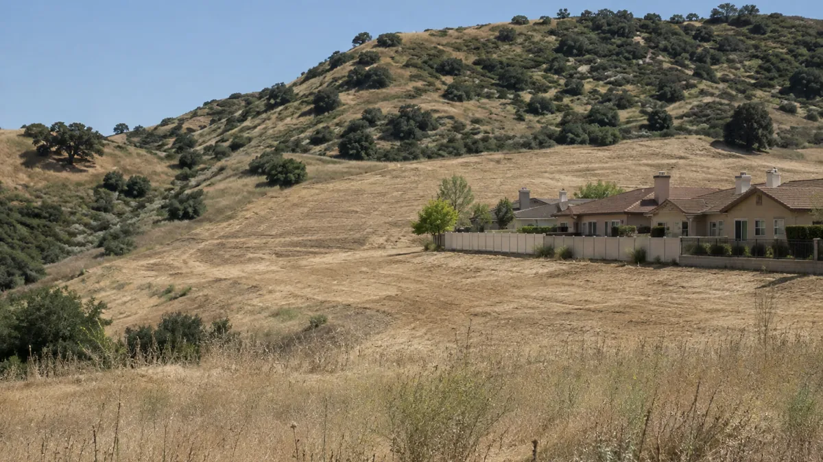 Hillside lot cleared of dry brush behind homes on the edge of Chino Hills, CA